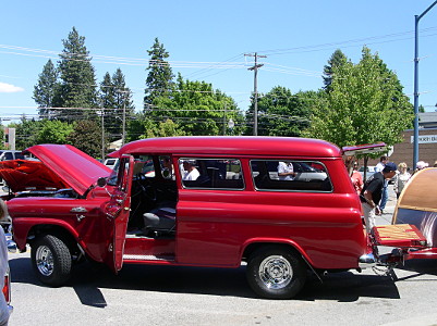 [This two-door parked all red vehicle has the driver's door open, the hood open, and the back end tailgate and lift glass open.]